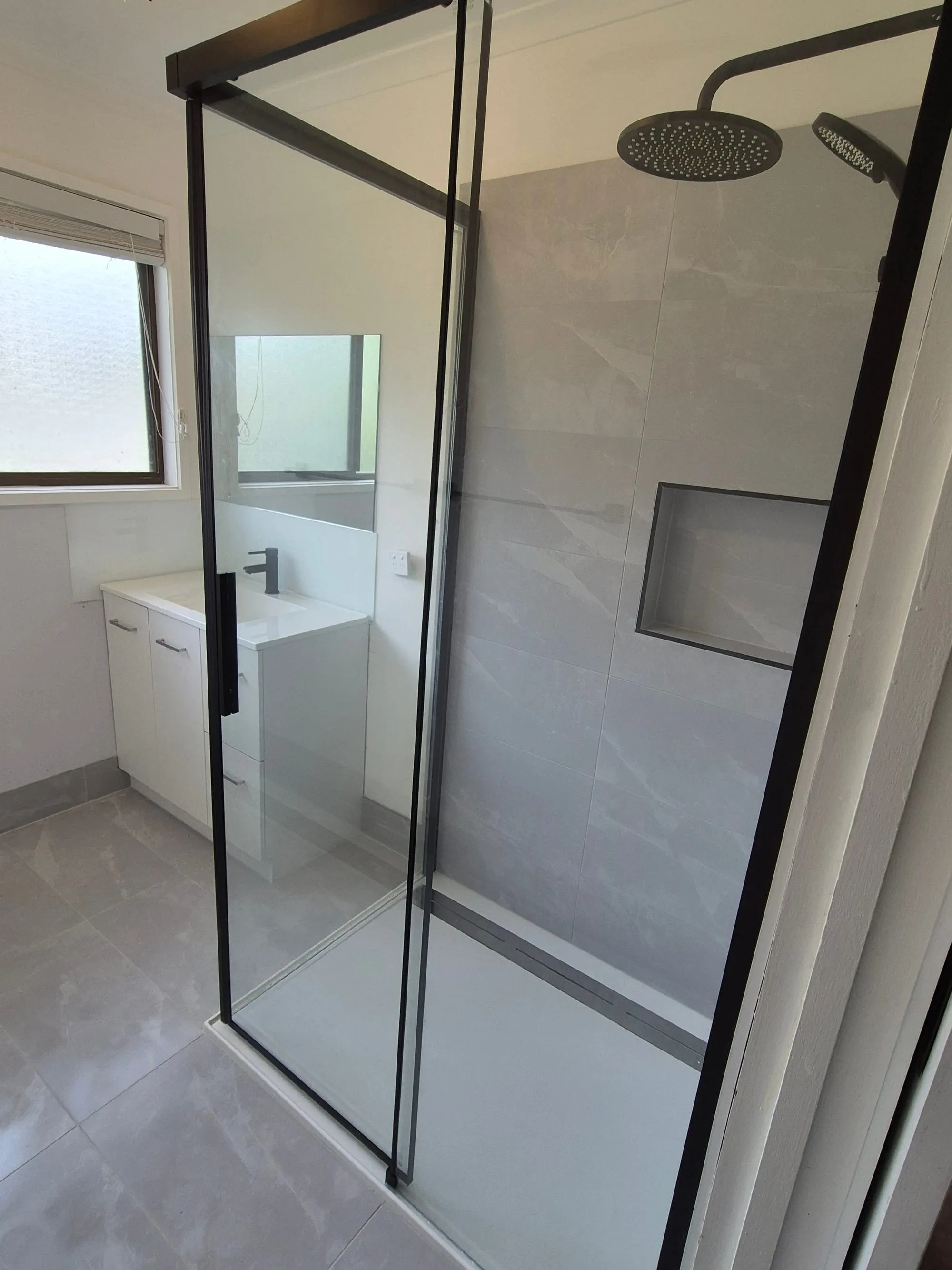 Shower base and floor tile, with the black-framed screen in the foreground