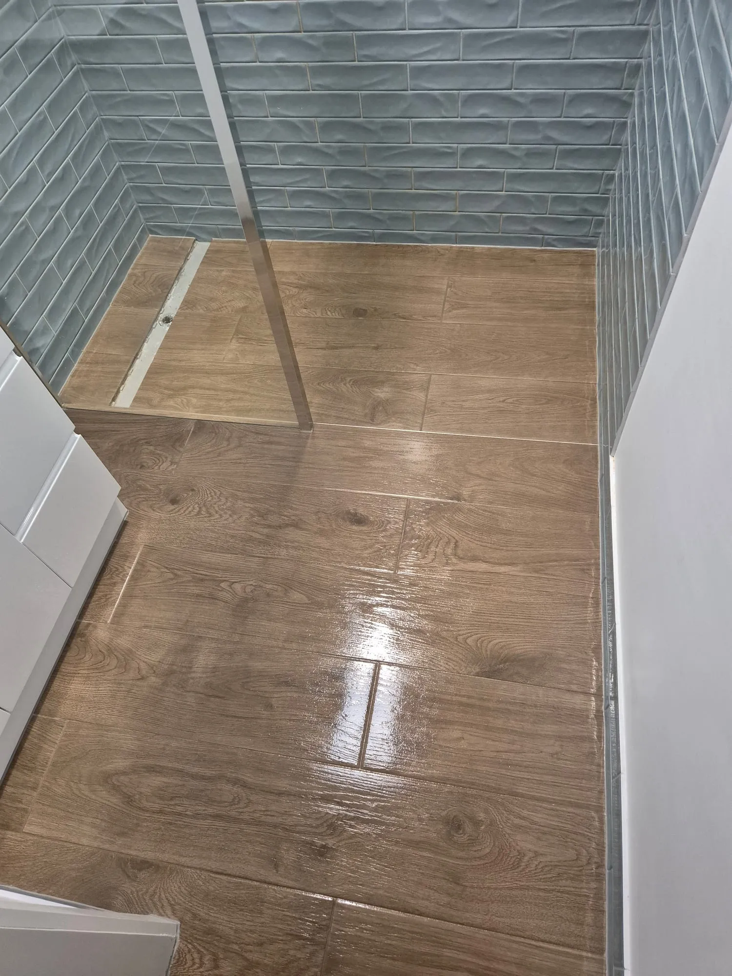 A bathroom tiled out before fit-off, showing the floor waste set into the tile