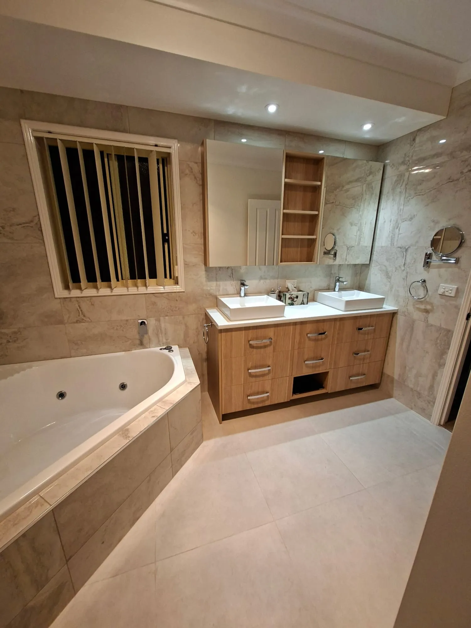 The same room from the doorway, showing the spa bath, vanity and mirror