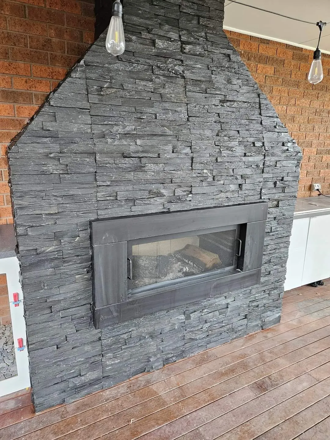 Close view of the stacked stone chimney and the firebox