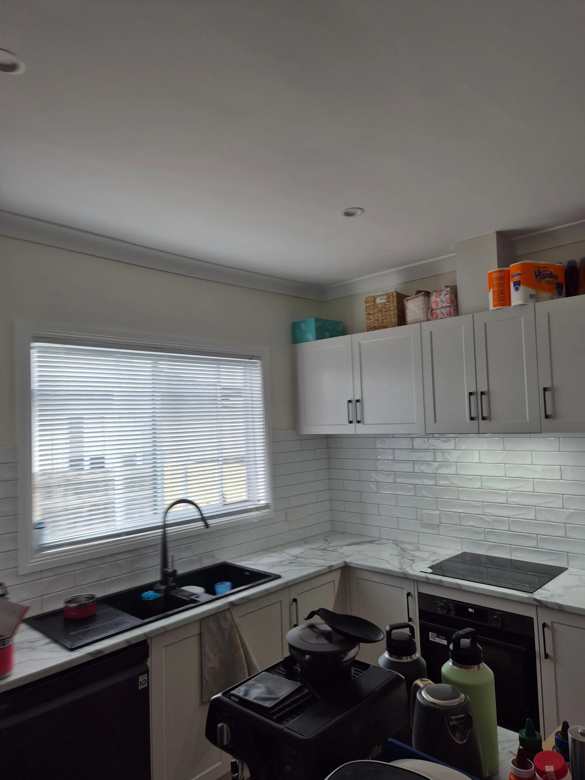 Overhead cupboards and the splashback running to the window