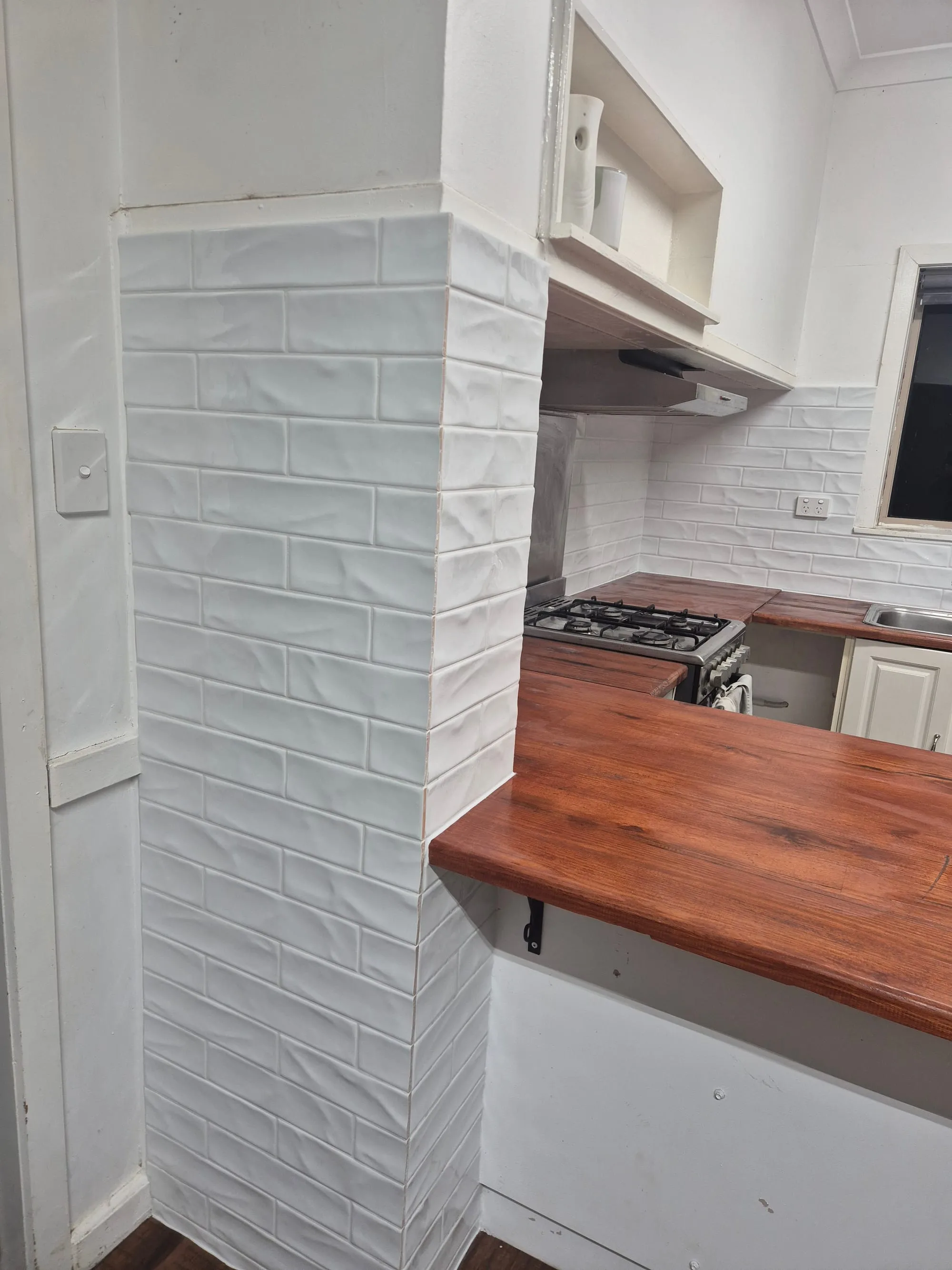 Close view of the subway tile splashback behind the cooktop