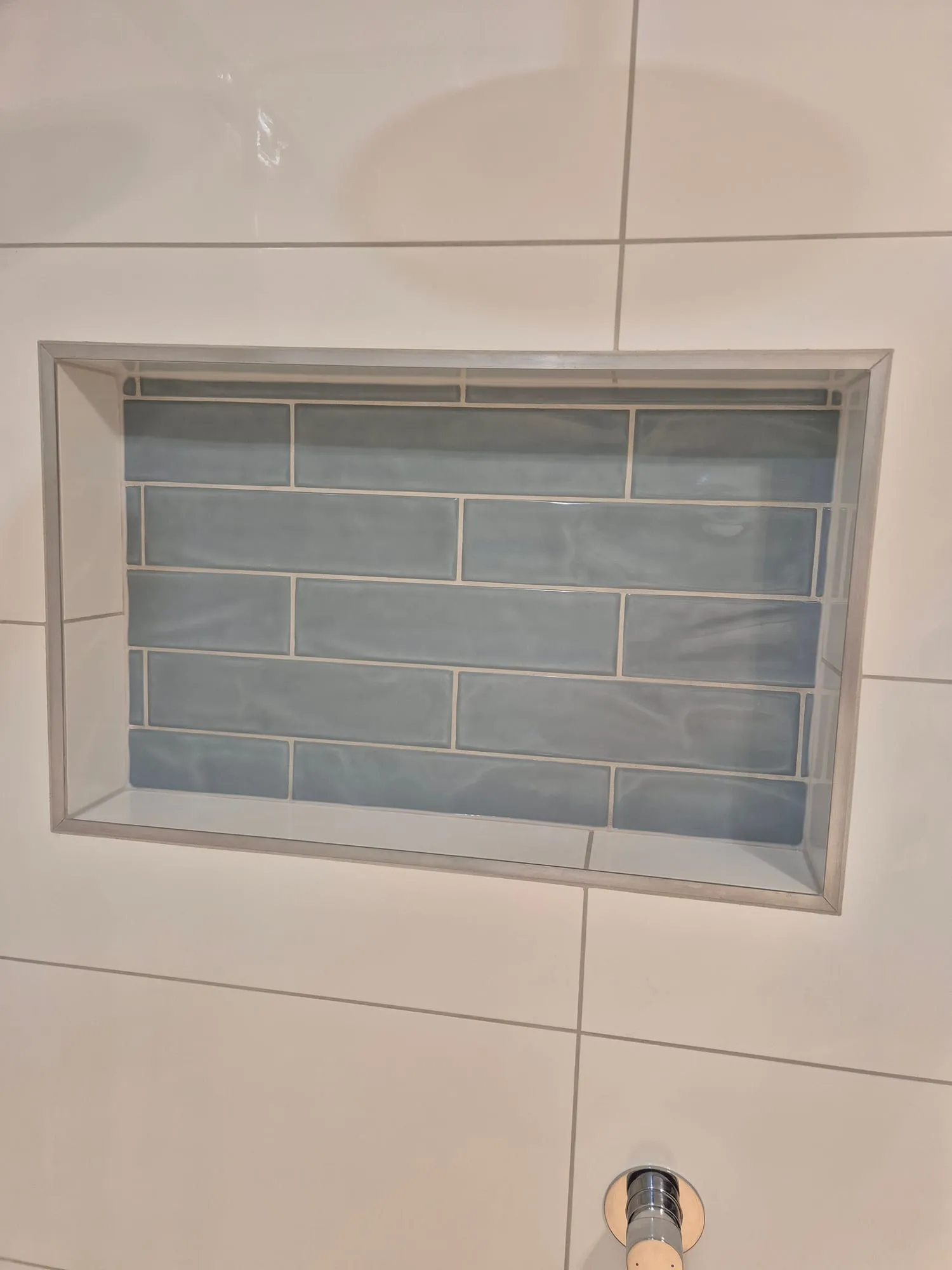 Close view of the blue subway tile set into the niche