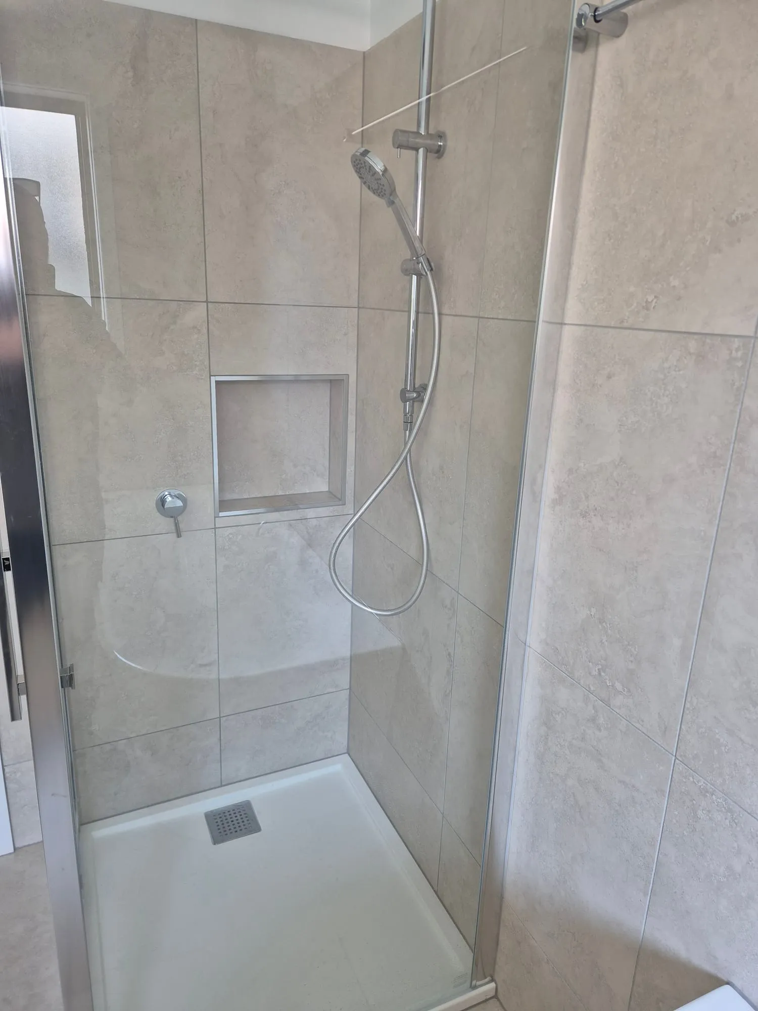 Shower with a recessed niche and a rail shower