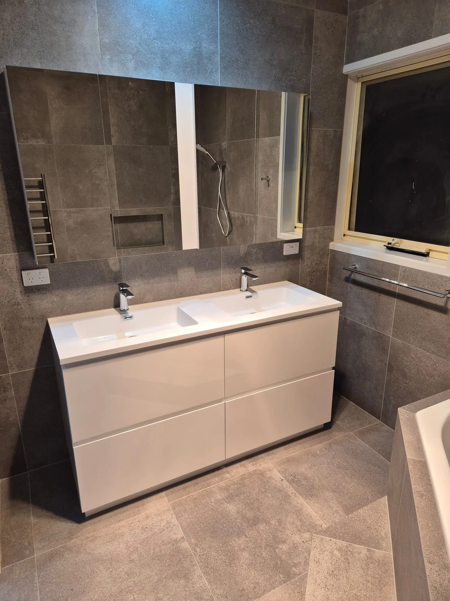 Double vanity and mirror below the window